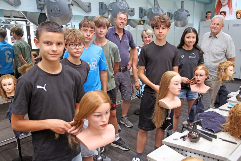 Kreishandwerksmeister Jürgen Seißler (rechts) schaute mit dem Bildungs-Manager des Bildungs-Zentrums in Ingolstadt, Markus Hipp (Mitte), den Teilnehmerinnen und Teilnehmern der Ferien-Werkstatt über die Schulter und kam mit ihnen ins Gespräch. Angeleitet wurden die Teenager hier von Friseur-Ausbilderin Monika Westner. Foto: Foto: Max Foerster